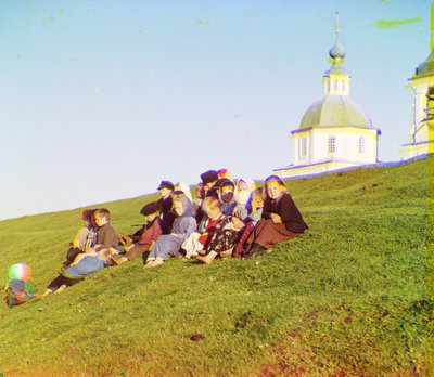 Russian children sitting on the side of a hill near a church and bell tower in the countryside near White Lake, in the north of European Russia, 1905-1915 by Sergey Prokudin Gorsky